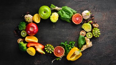 C vitamini içeren gıdalar: Portakal, limon, elma, gül, sarımsak, brokoli, elma, kivi, ıspanak. Üst te. Kahverengi arka planda.