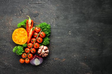 Siyah bir arka plan üzerinde taze sebze. Avokado, domates, sarımsak, maydanoz, kırmızı biber. Üst te. Metniniz için boş alan.