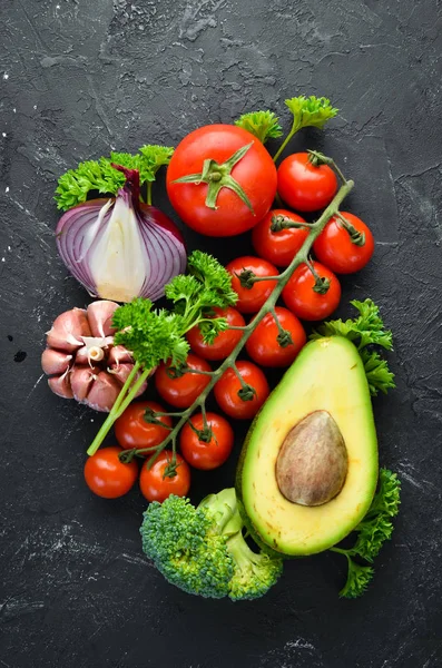 Verse Groenten Een Zwarte Achtergrond Avocado Tomaten Knoflook Peterselie Paprika — Stockfoto