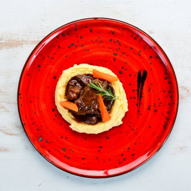 Kırmızı tabakta sığır eti ile patates püresi. Üst te. Metniniz için boş alan.