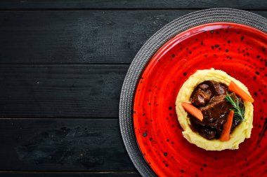 Kırmızı tabakta sığır eti ile patates püresi. Üst te. Metniniz için boş alan.