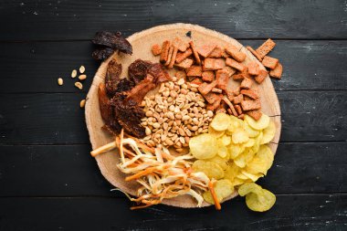 Biraya atıştırmalık. Cips, tuzlu fındık, kurutulmuş balık eti. Eski arka planda. ücretsiz kopyalama alanı.