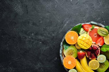 Tahta bir kutuda meyveler. Narenciye, kavun, nar, çilek, muz. Üst te. Metniniz için boş alan.