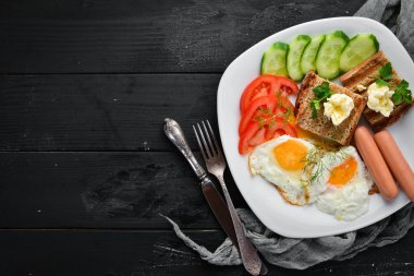 Kahvaltı: yumurta, sosis ve sebze tabakta. Üst te. Metniniz için boş alan. Rustik stil.