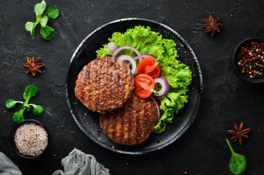 sebze ile burger için kızarmış pirtilet. Ahşap arka plan üst görünümünde siyah bir tabak ta. Metniniz için boş alan. Düz yatıyordu