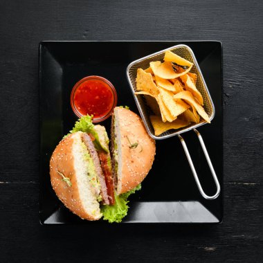 Etli burger ve aperatifler nachos. Tabakta. Üst te. Metniniz için boş alan. Rustik stil.