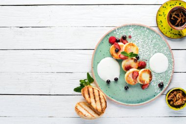 Çilek ve ekşi krema ile Peynir krep. Kahvaltı. Tabakta. Üst te. Düz döşeme kompozisyonU Ücretsiz kopyalama alanı.