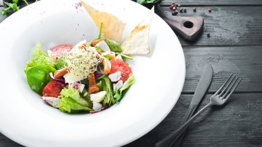 Brie peynir, kiraz domates ve ıspanak ile sebze salatası. Tabakta. Üst te. Metniniz için boş alan. Rustik stil.