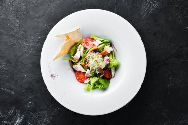 Brie peynir, kiraz domates ve ıspanak ile sebze salatası. Tabakta. Üst te. Metniniz için boş alan. Rustik stil.