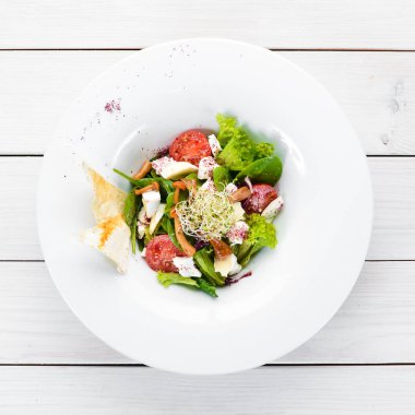 Brie peynir, kiraz domates ve ıspanak ile sebze salatası. Tabakta. Üst te. Metniniz için boş alan. Rustik stil.