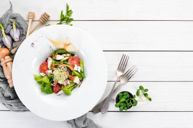 Brie peynir, kiraz domates ve ıspanak ile sebze salatası. Tabakta. Üst te. Metniniz için boş alan. Rustik stil.