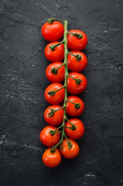 Fresh cherry tomatoes on a twig. Vegetables. Top view. Free space for your text. On a wooden background.