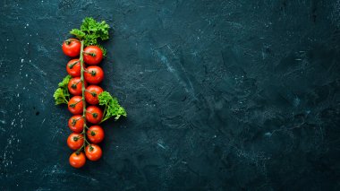 Fresh cherry tomatoes on a twig. Vegetables. Top view. Free space for your text. On a wooden background.