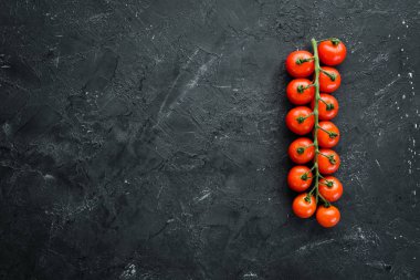 Fresh cherry tomatoes on a twig. Vegetables. Top view. Free space for your text. On a wooden background.