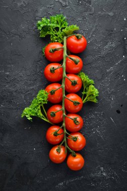 Fresh cherry tomatoes on a twig. Vegetables. Top view. Free space for your text. On a wooden background.