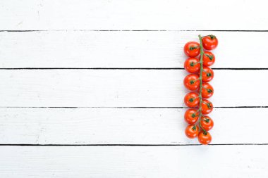 Fresh cherry tomatoes on a twig. Vegetables. Top view. Free space for your text. On a wooden background.