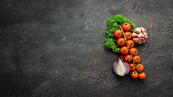 Fresh cherry tomatoes on a twig. Vegetables. Top view. Free space for your text. On a wooden background.