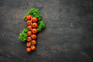 Fresh cherry tomatoes on a twig. Vegetables. Top view. Free space for your text. On a wooden background.