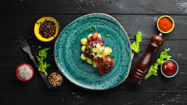 Fırında patatesli tavuk kalçaları. Tabakta. Üst te. Metniniz için boş alan. Rustik stil.