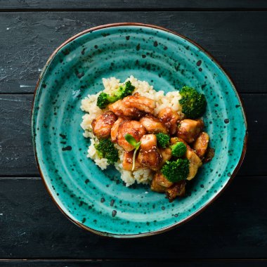 Tavuk fileto su filetosu ve brokolili pilav. Tay mutfağı. Tabakta. Üst te. Metniniz için boş alan. Rustik stil.