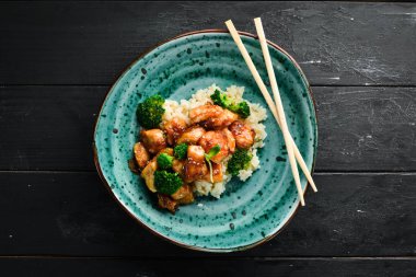 Tavuk fileto su filetosu ve brokolili pilav. Tay mutfağı. Tabakta. Üst te. Metniniz için boş alan. Rustik stil.