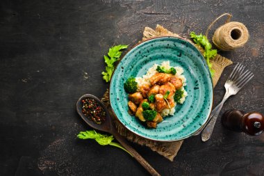 Tavuk fileto su filetosu ve brokolili pilav. Tay mutfağı. Tabakta. Üst te. Metniniz için boş alan. Rustik stil.