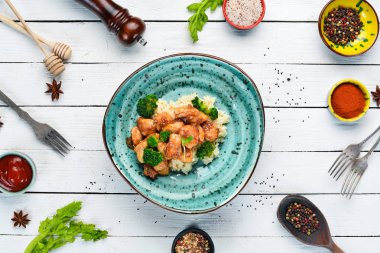 Tavuk fileto su filetosu ve brokolili pilav. Tay mutfağı. Tabakta. Üst te. Metniniz için boş alan. Rustik stil.