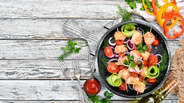 Chicken kebab with vegetables. Kebab in a black plate. Top view. Free copy space.