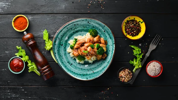 Tavuk fileto su filetosu ve brokolili pilav. Tay mutfağı. Tabakta. Üst te. Metniniz için boş alan. Rustik stil.