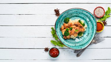 Tavuk fileto su filetosu ve brokolili pilav. Tay mutfağı. Tabakta. Üst te. Metniniz için boş alan. Rustik stil.