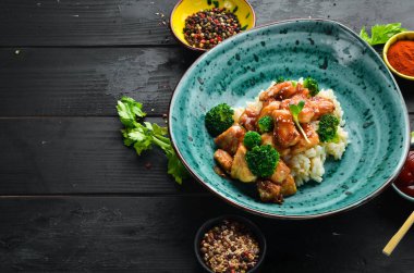 Tavuk fileto su filetosu ve brokolili pilav. Tay mutfağı. Tabakta. Üst te. Metniniz için boş alan. Rustik stil.