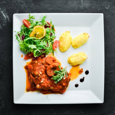 Bir tabakta domates sosu ve patates ile kemik üzerinde pişmiş biftek. Üst te. Metniniz için boş alan.