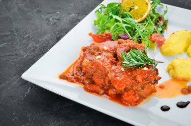 Bir tabakta domates sosu ve patates ile kemik üzerinde pişmiş biftek. Üst te. Metniniz için boş alan.