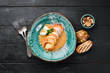 Karamel tepesi, dondurma ve fındık ile Peynir krep. Kahvaltı. Tabakta. Üst te. Düz döşeme kompozisyonU Ücretsiz kopyalama alanı.