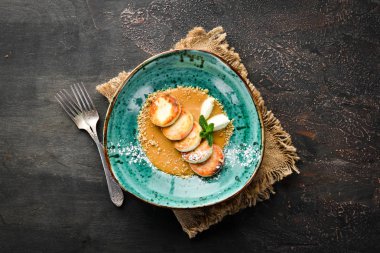 Karamel tepesi, dondurma ve fındık ile Peynir krep. Kahvaltı. Tabakta. Üst te. Düz döşeme kompozisyonU Ücretsiz kopyalama alanı.