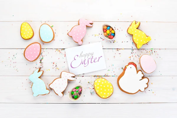 Ostergrüßkarte Mit Bunten Lebkuchen Und Süßigkeiten Auf Weißem Holzgrund Ansicht — Stockfoto