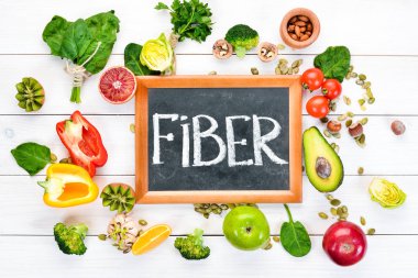 Doğal lif içeren gıdalar: avokado, kivi, elma, domates, ıspanak, kırmızı biber, portakal, limon. Üst te. Metniniz için boş alan. Beyaz arka planda.