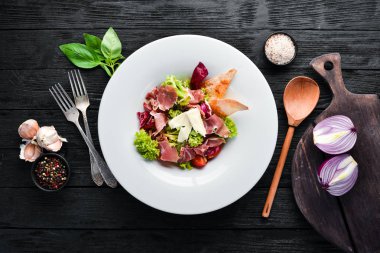 Brie peynirve prosciutto ile sebze salatası. Tabakta. Üst te. Metniniz için boş alan. Rustik stil.