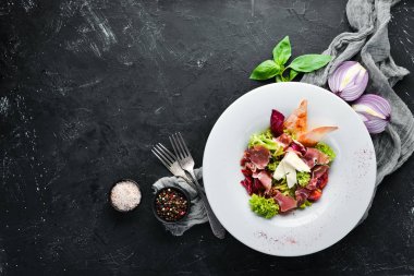 Brie peynirve prosciutto ile sebze salatası. Tabakta. Üst te. Metniniz için boş alan. Rustik stil.