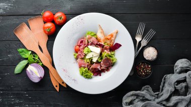 Brie peynirve prosciutto ile sebze salatası. Tabakta. Üst te. Metniniz için boş alan. Rustik stil.