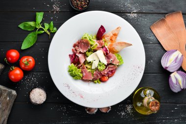 Brie peynirve prosciutto ile sebze salatası. Tabakta. Üst te. Metniniz için boş alan. Rustik stil.