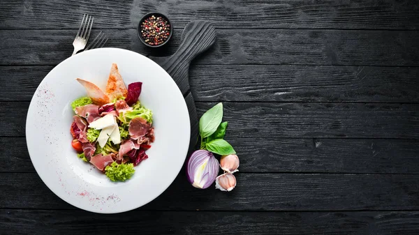 Brie peynirve prosciutto ile sebze salatası. Tabakta. Üst te. Metniniz için boş alan. Rustik stil.