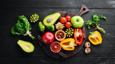 Lif içeren meyve ve sebzeler: Avokado, kivi, elma, domates, ıspanak, kırmızı biber, portakal, limon. Üst te. Metniniz için boş alan. Siyah arka planda.