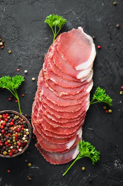 Gesneden Gerookt Vlees Met Kruiden Specerijen Een Zwarte Houten Achtergrond — Stockfoto