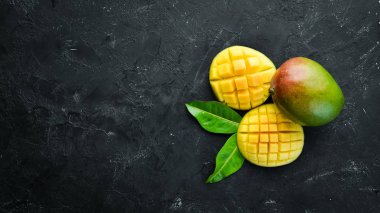 Siyah bir arka plan üzerinde taze mango. Üst te. Metniniz için boş alan.
