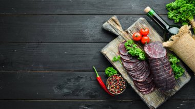 Baharat ve otlar ile kurutulmuş dana eti. Eski siyah masada biftek. Üst te. Metniniz için boş alan.