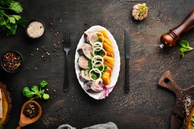 Patates ve soğanile tuzlu balık. Ukrayna Geleneksel Mutfağı. Eski arka planda. ücretsiz kopyalama alanı.