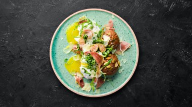 Proshutto, yumurta ve arugula ile sandviç. Kahvaltı. Tabakta. Üst te. Düz döşeme kompozisyonU Ücretsiz kopyalama alanı.