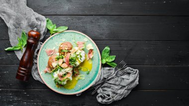 Proshutto, yumurta ve arugula ile sandviç. Kahvaltı. Tabakta. Üst te. Düz döşeme kompozisyonU Ücretsiz kopyalama alanı.