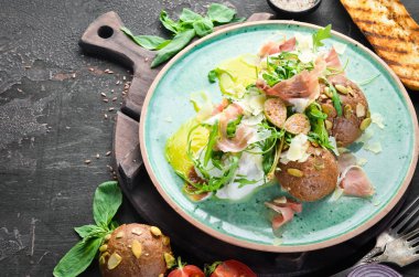 Proshutto, yumurta ve arugula ile sandviç. Kahvaltı. Tabakta. Üst te. Düz döşeme kompozisyonU Ücretsiz kopyalama alanı.